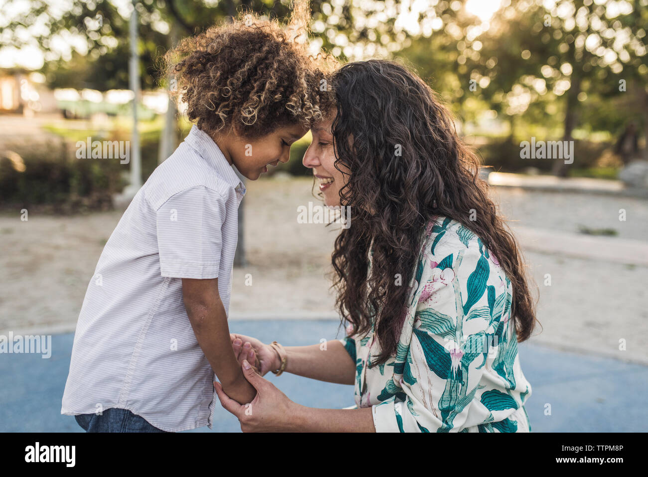 Vue latérale d'happy mother and son toucher front at park Banque D'Images