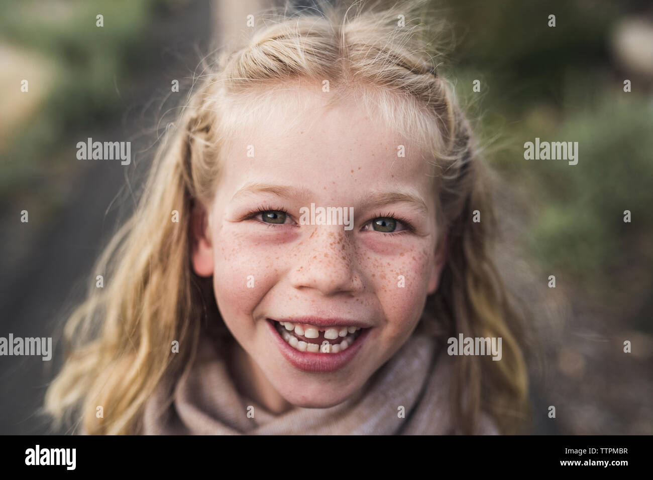 Close-up portrait of happy girl aux cheveux blonds standing in forest Banque D'Images