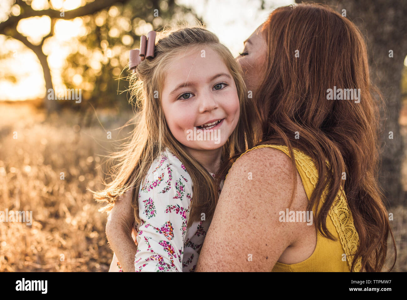 Close up of young girl embrassé par mère en Californie domaine Banque D'Images