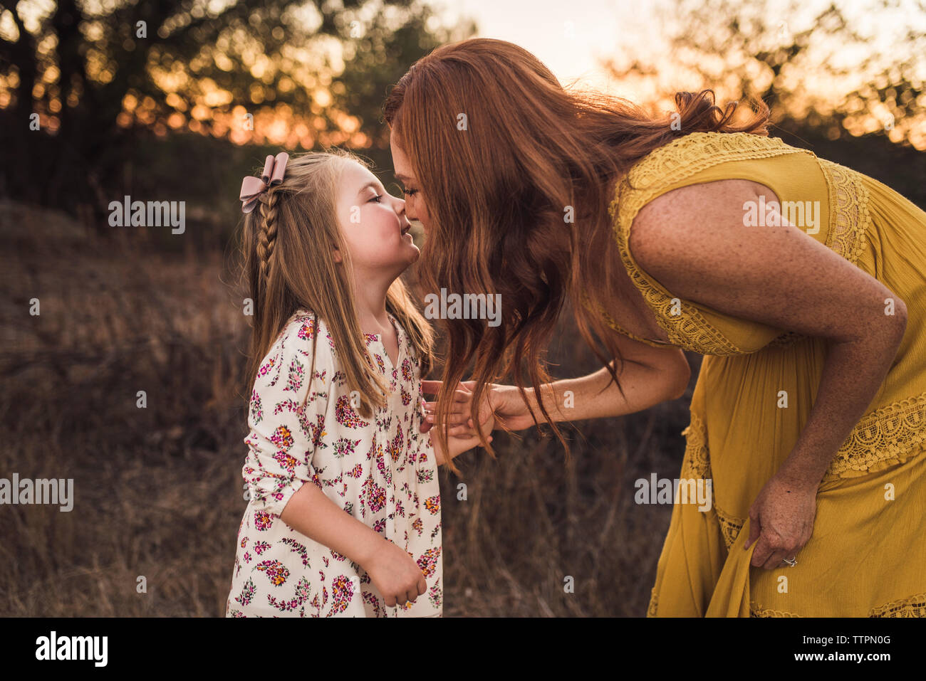 Femme en se penchant pour embrasser sa jeune fille en Californie domaine Banque D'Images