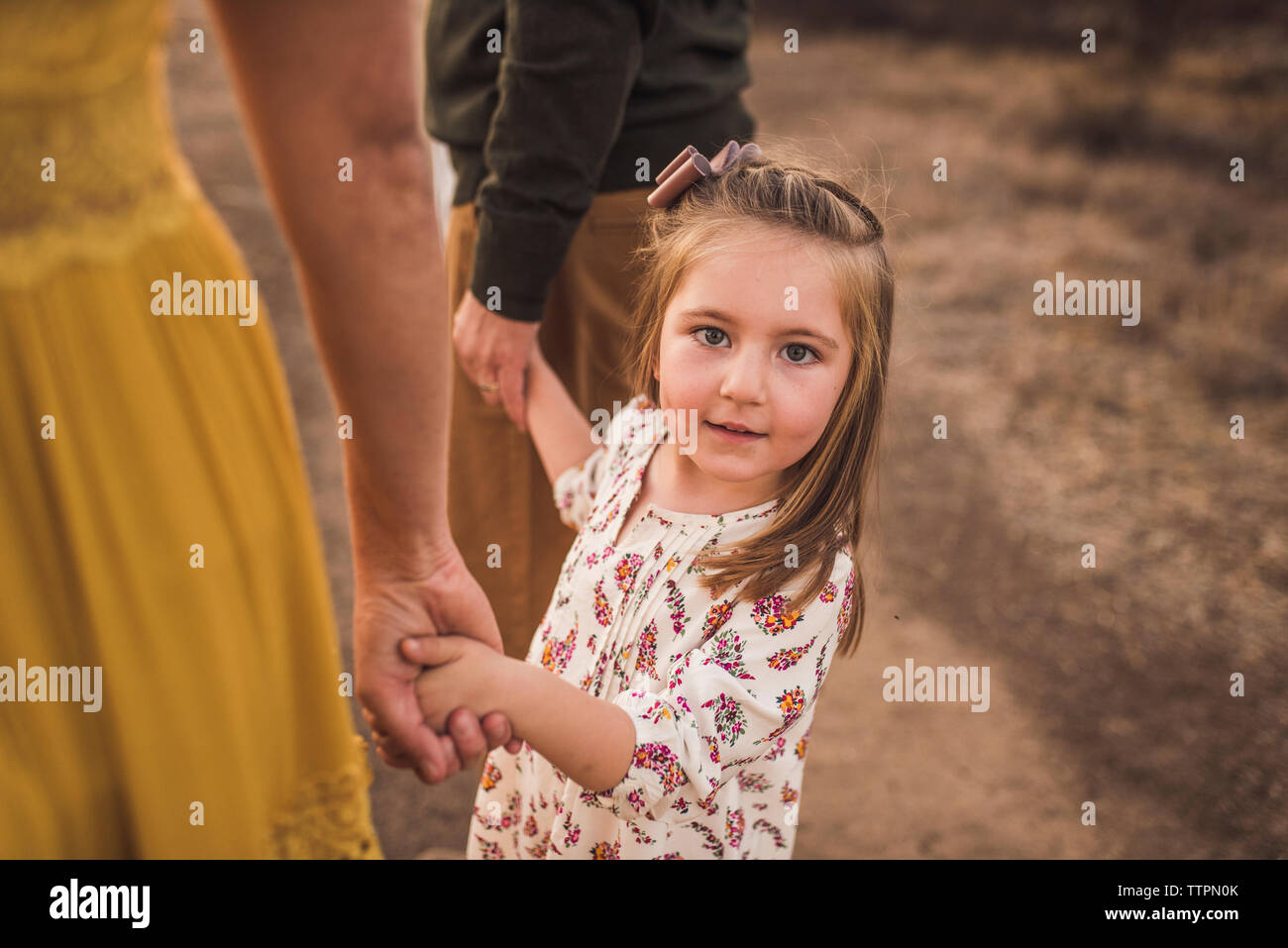 Young Girl holding parents part en Californie field at sunset Banque D'Images