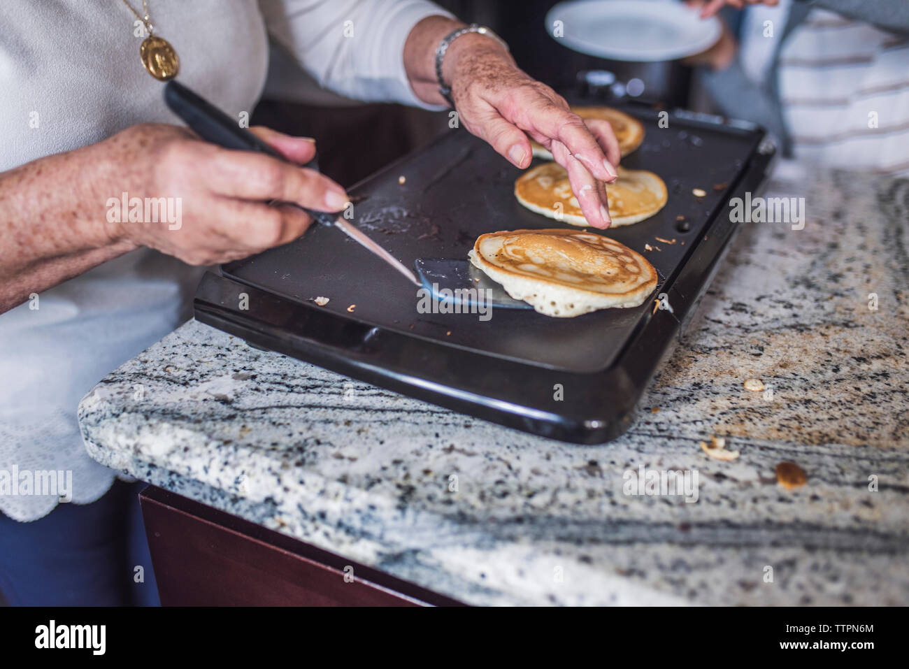Close up de grand-mère la cuisson des crêpes sur une crêpière Banque D'Images