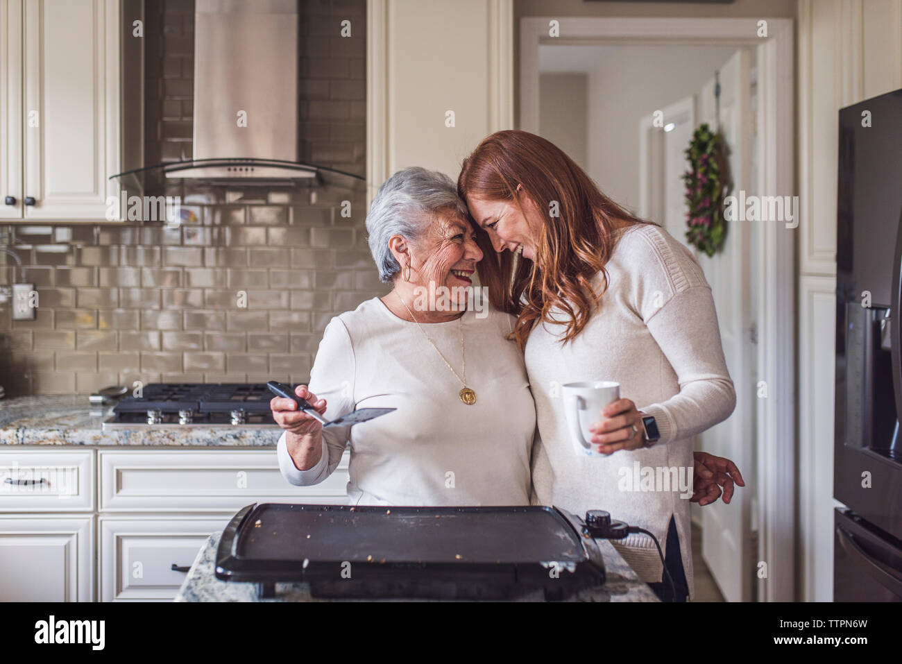 Senior woman et petite-fille adultes la cuisson des crêpes pour le petit déjeuner Banque D'Images