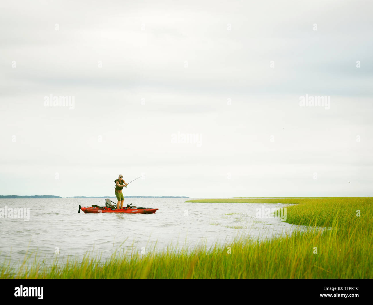 Pêche à la mouche un marais sur la côte Atlantique à partir d'un kayak. Banque D'Images