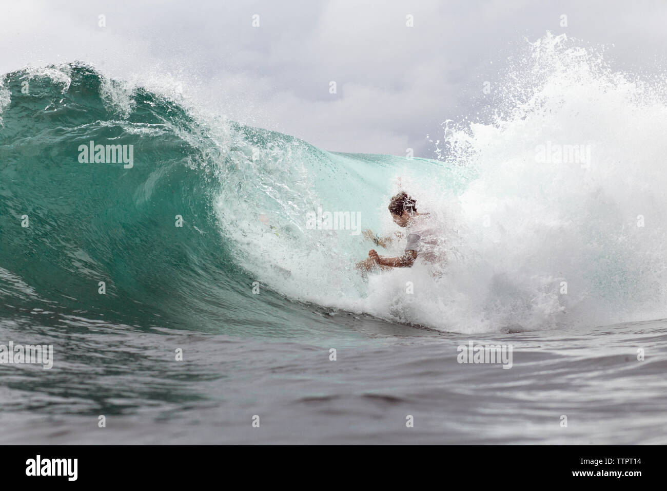 Jeune homme de surf sur les vagues de la mer immense Banque D'Images