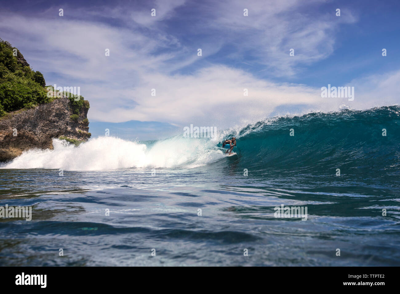 Homme surf sur mer contre ciel à Bali Banque D'Images