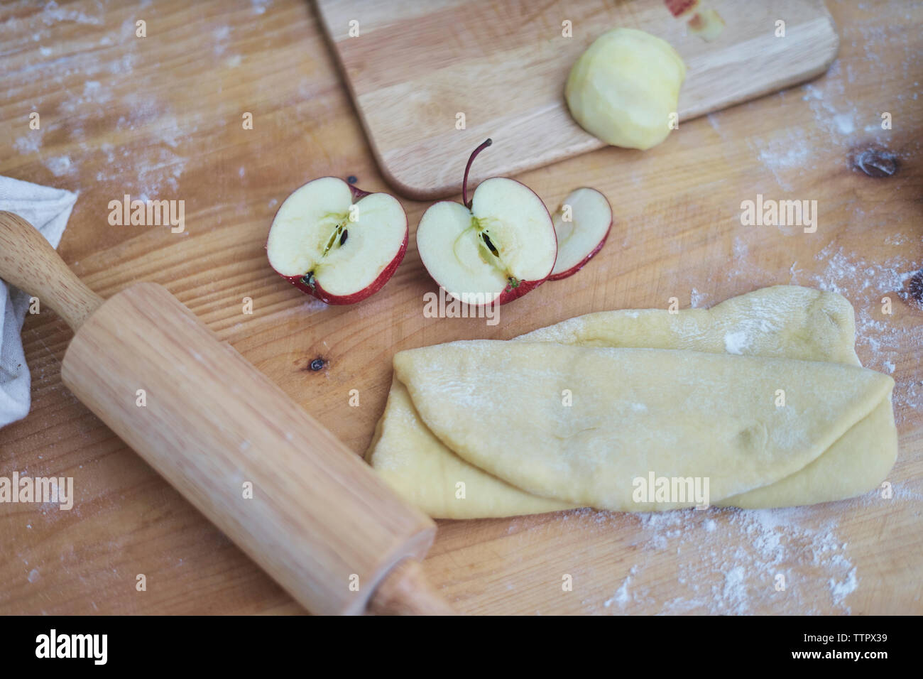 Close-up de tranches de pomme en pâte feuilletée et rouleau à pâtisserie sur compteur de cuisine Banque D'Images