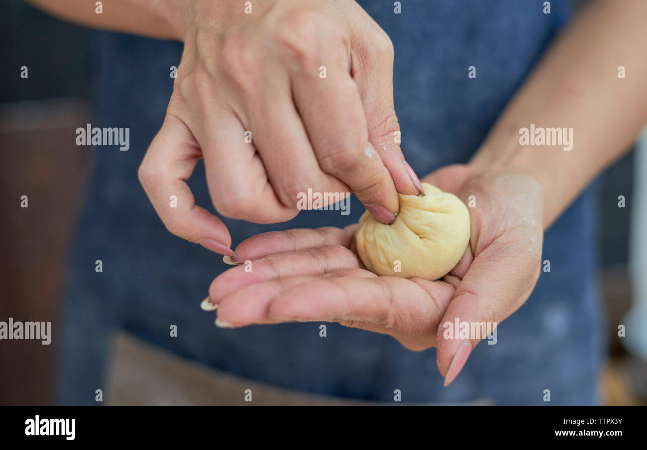 Portrait femme faisant boule de pâte à la maison Banque D'Images