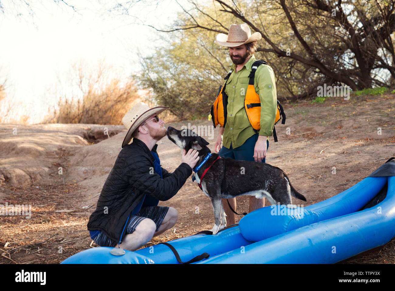 L'homme jouant avec chien accroupi par kayak gonflable dans l'aménagement  forestier Photo Stock - Alamy