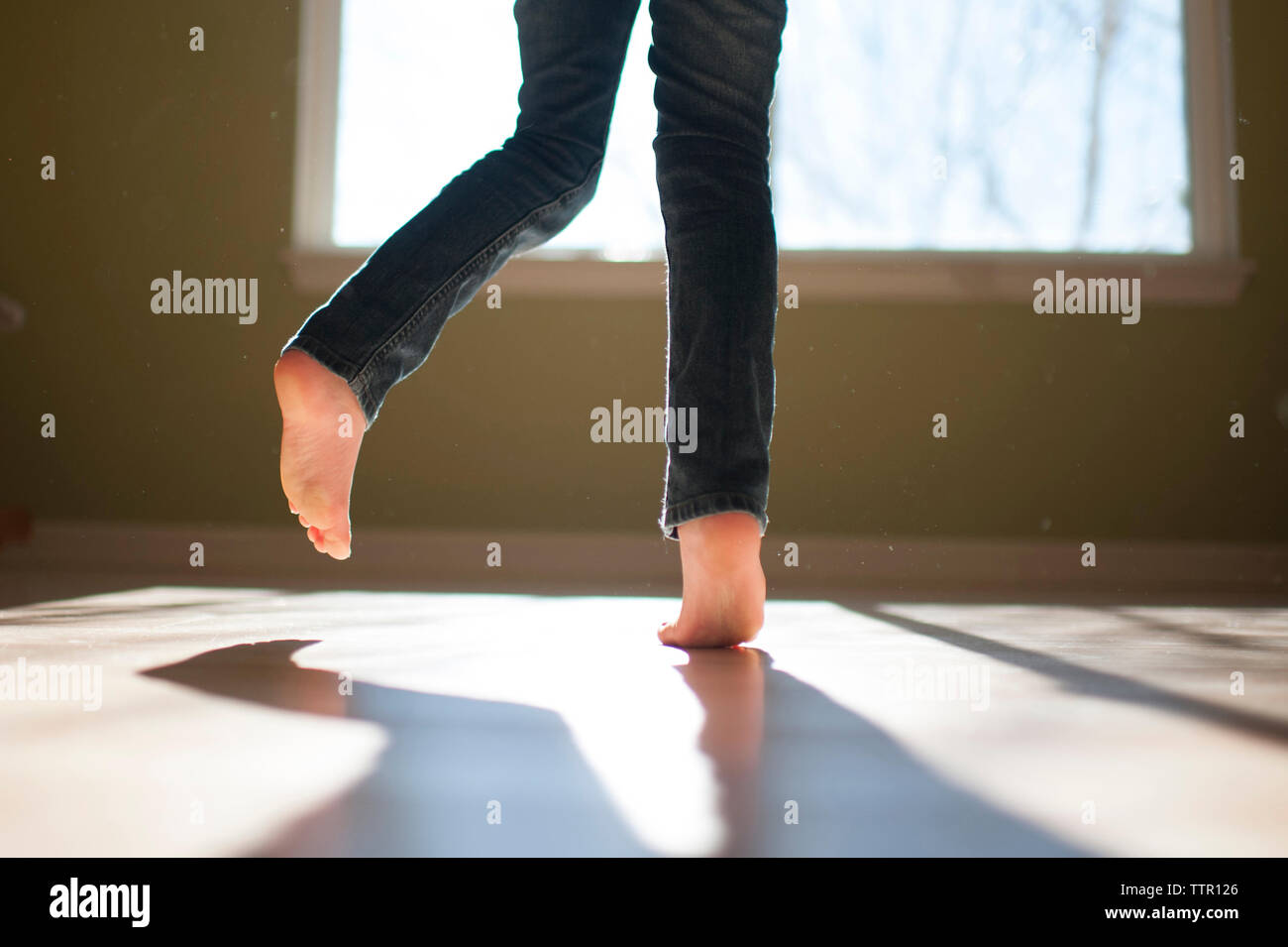 La section basse de girl dancing sur le plancher à la maison Banque D'Images