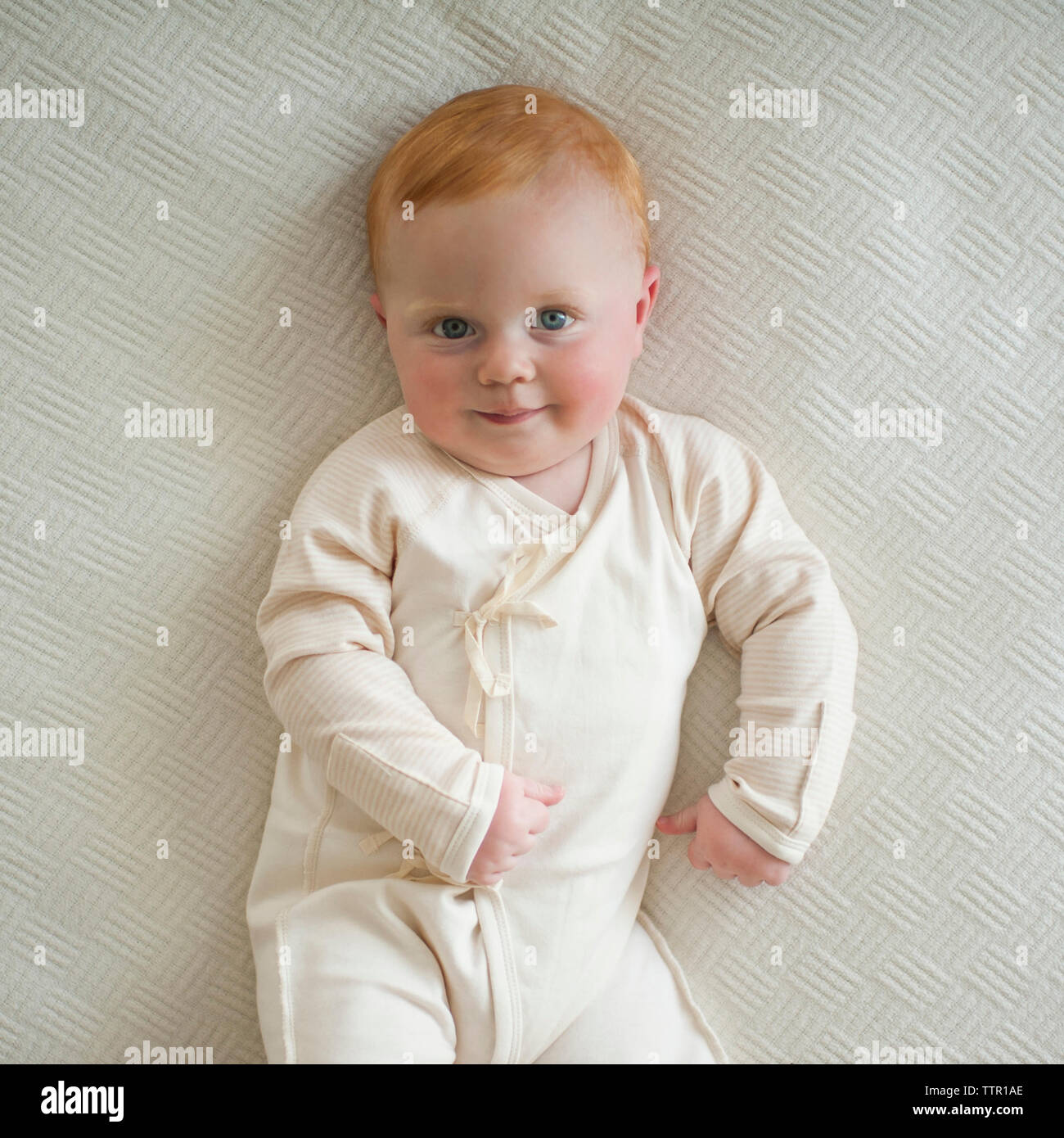Passage portrait of cute baby boy lying on bed Banque D'Images