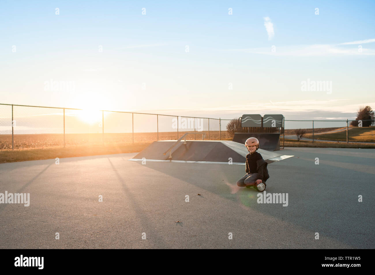 Young boy riding hover board à skate park avec un grand sourire Banque D'Images