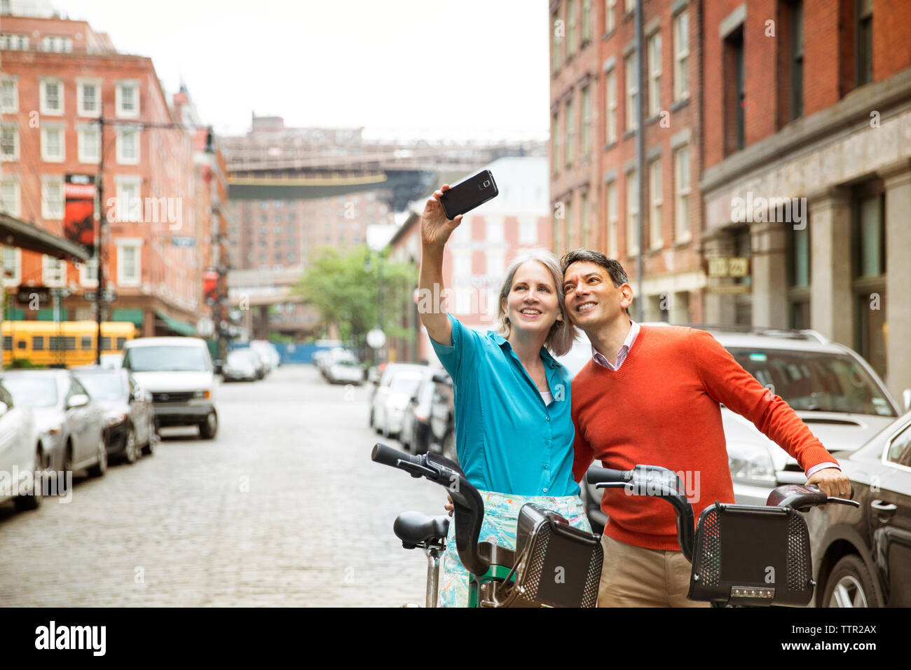 D'âge mûr en tenant debout selfies avec des vélos on city street Banque D'Images