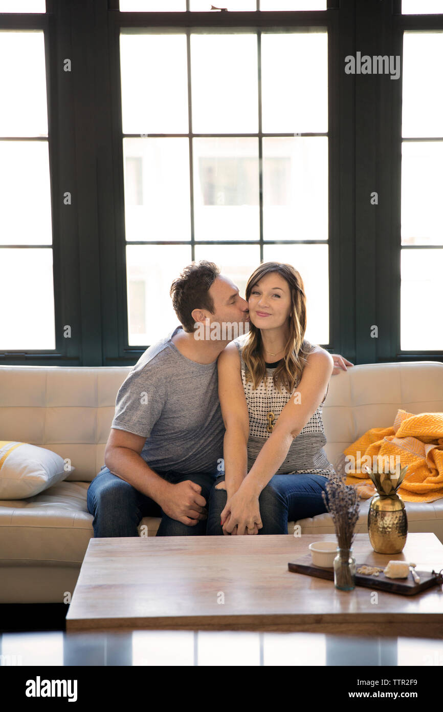 Couple heureux girlfriend while sitting on sofa at home Banque D'Images