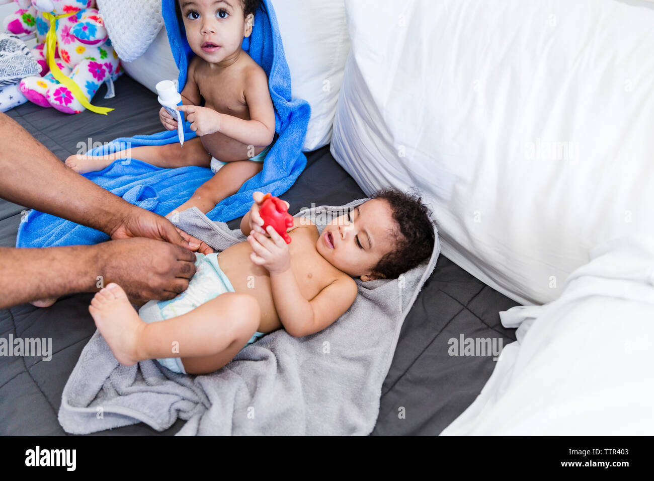 Cropped Mains Du Pere De Changer La Couche De Bebe Fille Avec Fille Assis Pres D Elle Photo Stock Alamy