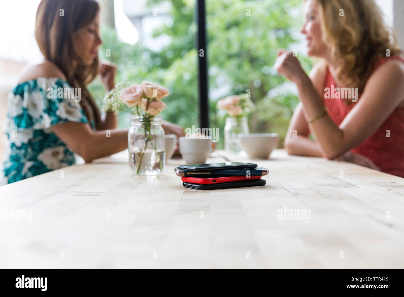 Amies le café ensemble au café avec des téléphones intelligents sur table Banque D'Images Amies le café ensemble au café avec des téléphones intelligents sur table Banque D'Images