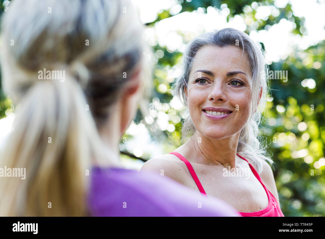 Smiling woman looking at friend in park Banque D'Images