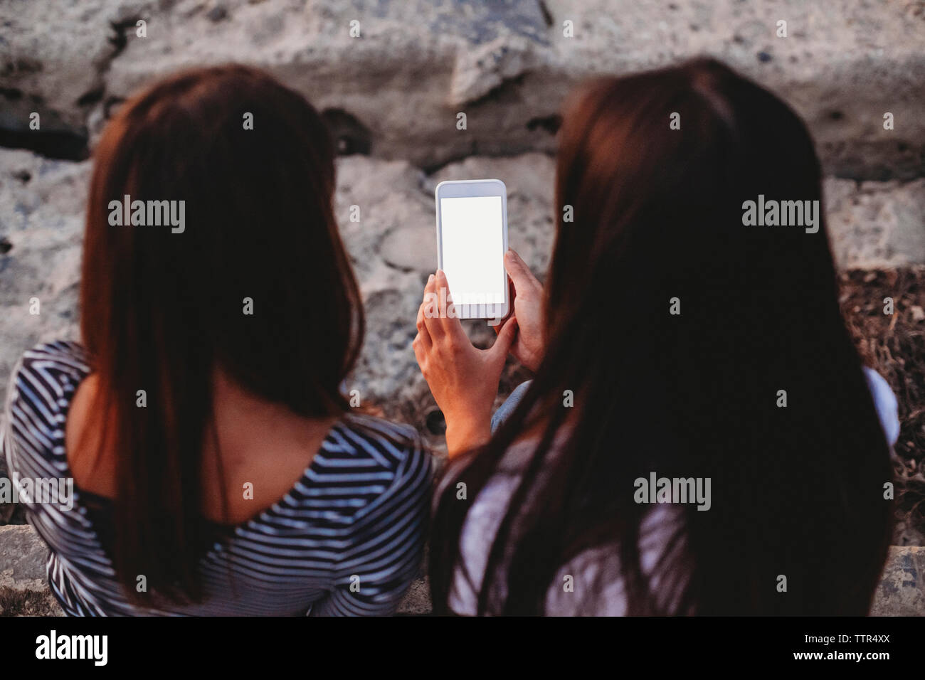 Portrait d'amies à l'aide de smart phone outdoors Banque D'Images