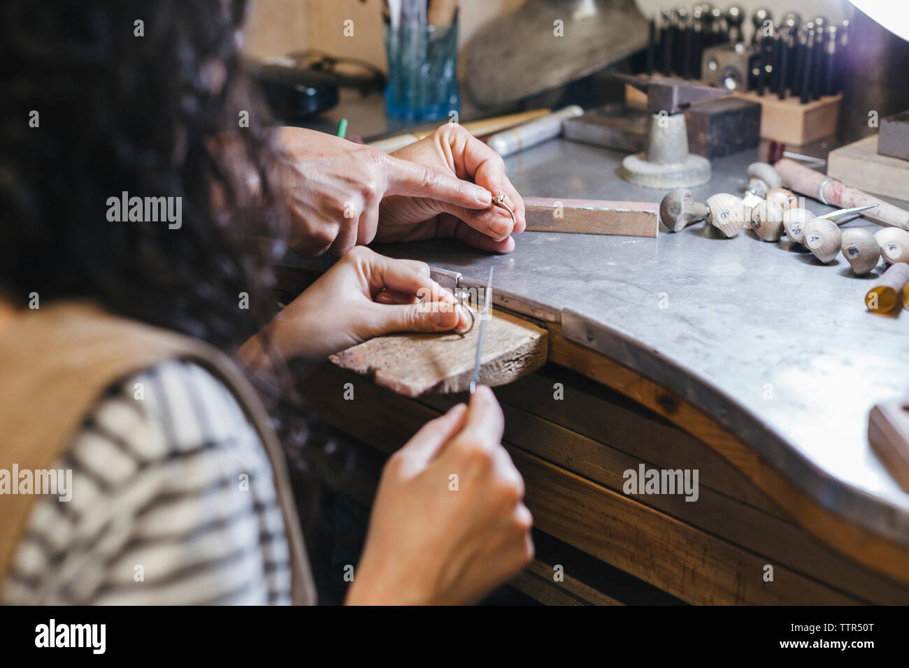 Les mains coupées de l'enseignement enseignant étudiant à l'anneau de forme sur la table à l'atelier Banque D'Images