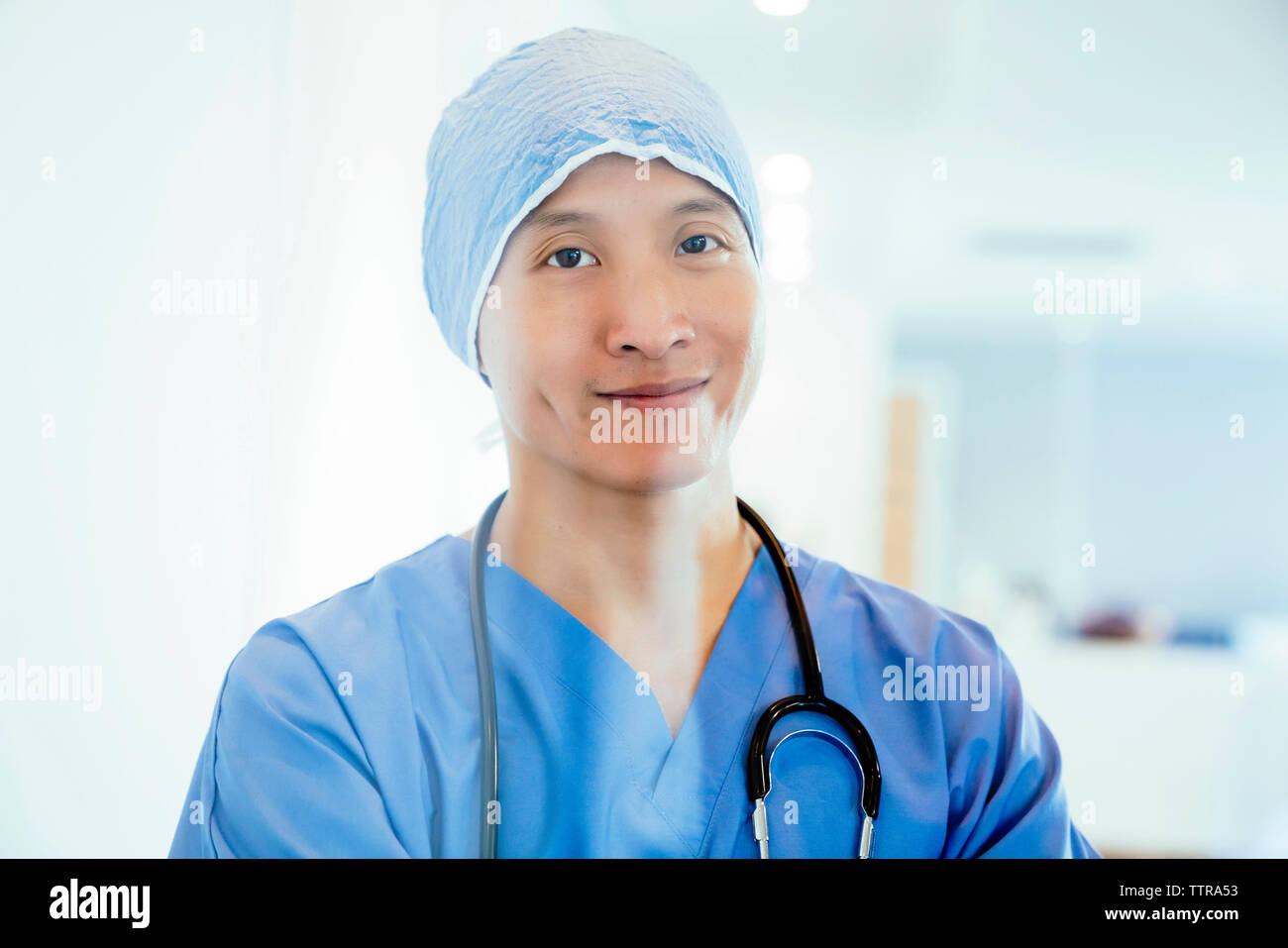 Portrait of smiling surgeon wearing surgical cap vu à travers la vitre Banque D'Images
