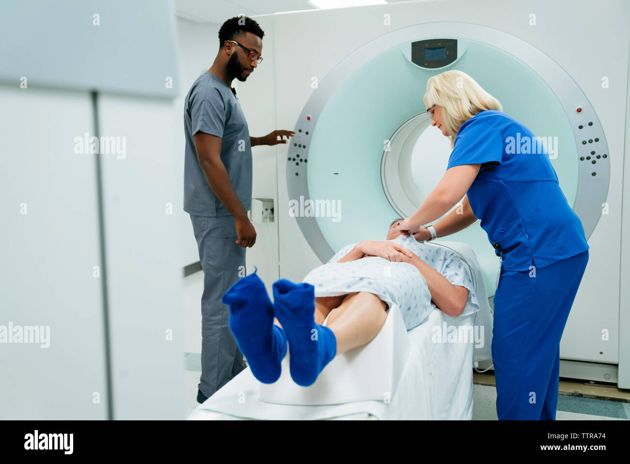 Médecin à l'infirmière à la préparation pour IRM d'un patient en salle d'examen Banque D'Images