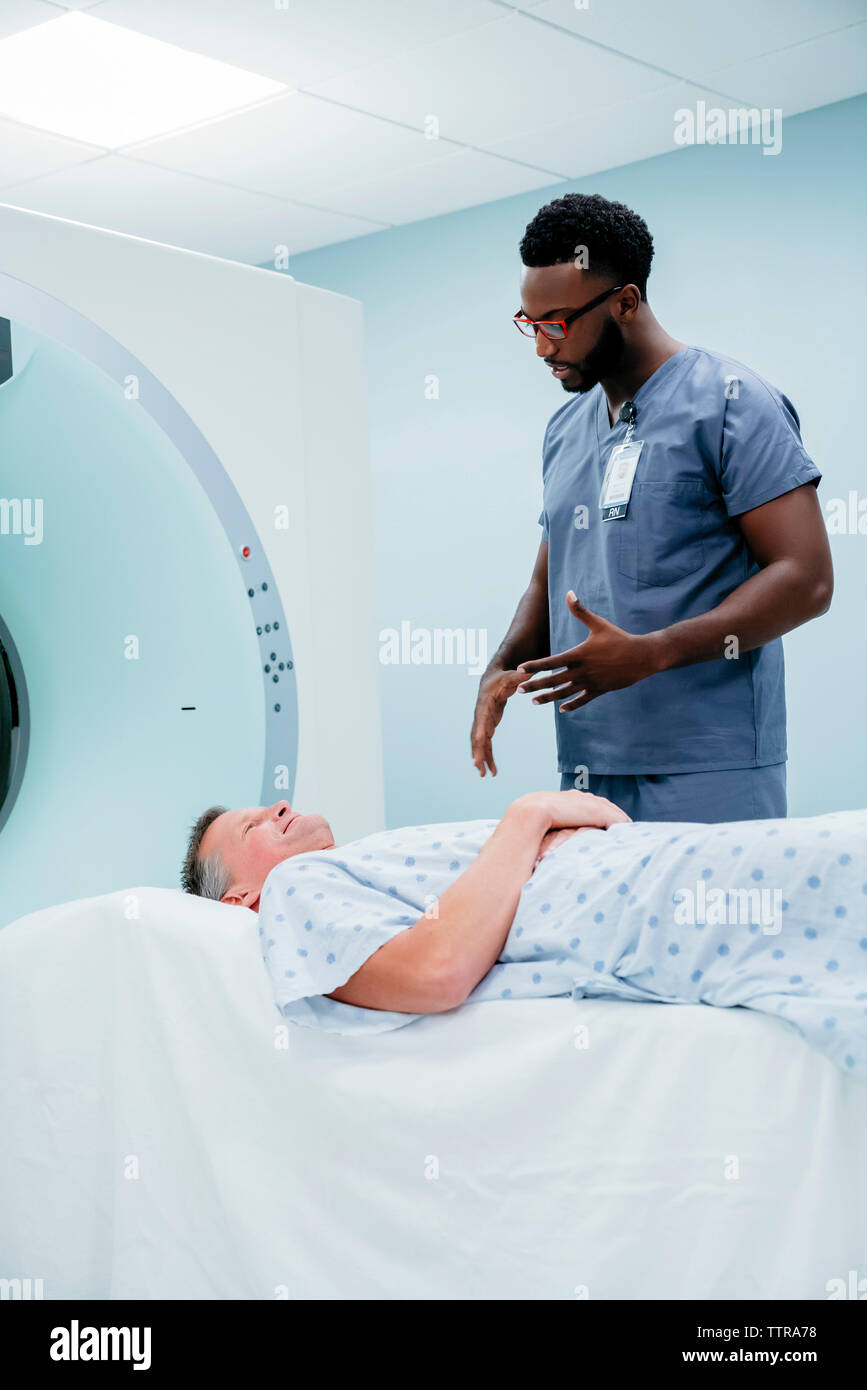 Doctor talking with patient couché sur IRM Scanner en salle d'examen Banque D'Images