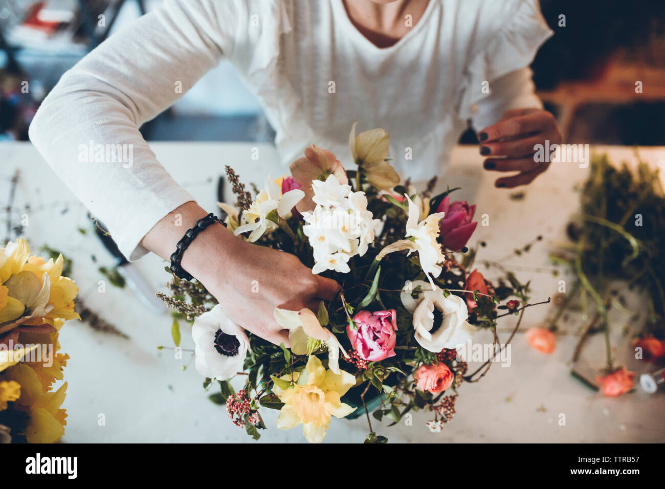 High angle midsection florist arranging flowers at store Banque D'Images