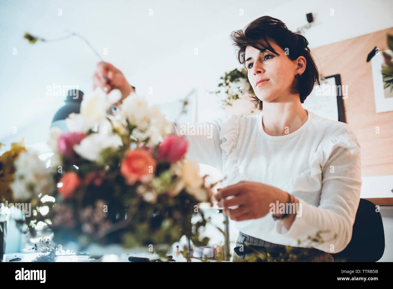 Fleuriste confiant l'organisation de magasin fleurs à Banque D'Images