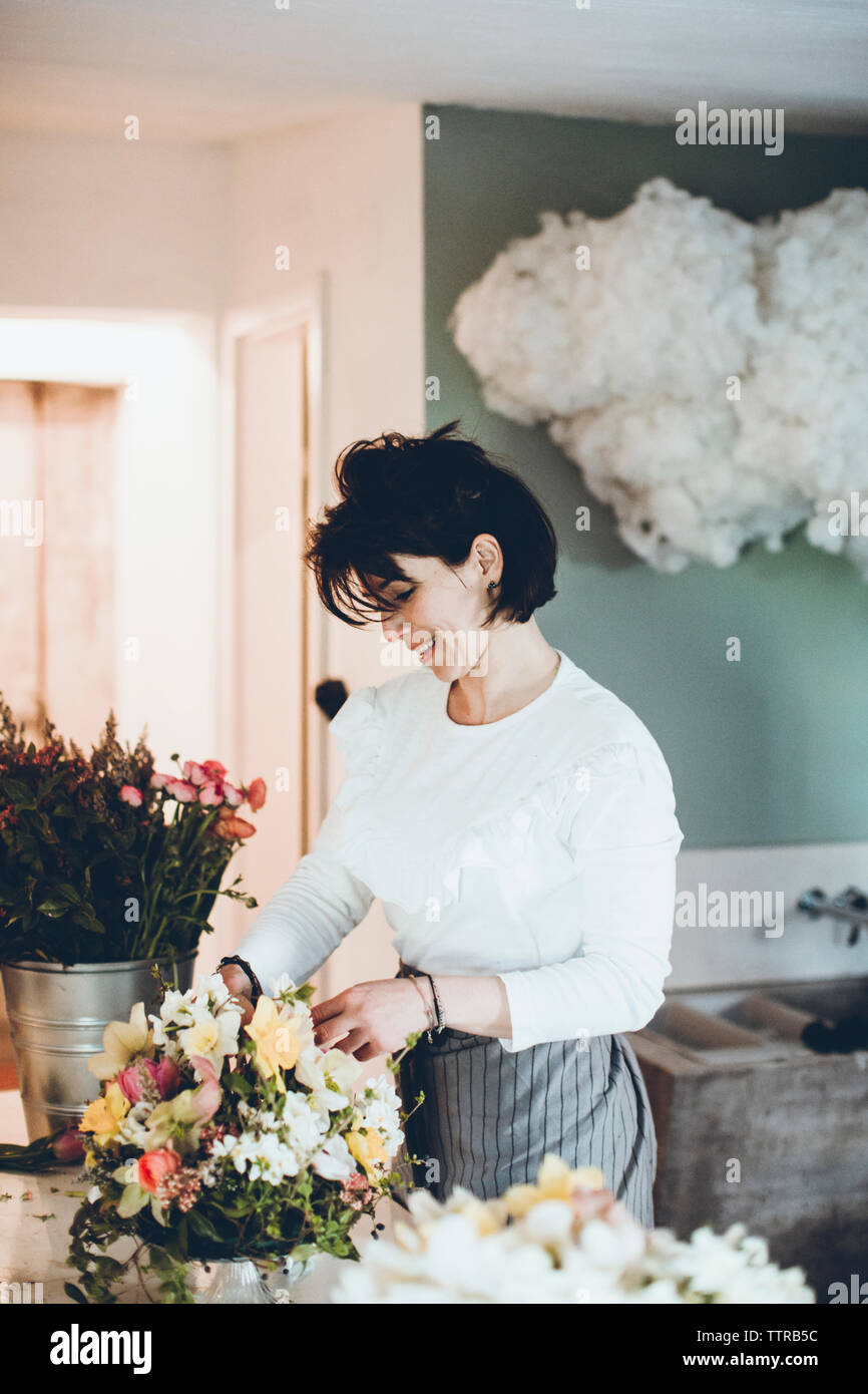 Fleuriste fleurs souriant à l'organisation de magasin Banque D'Images