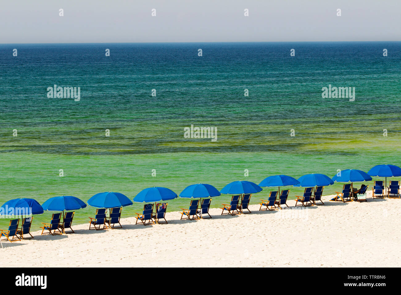 Chaises longues et parasols à la plage Banque D'Images