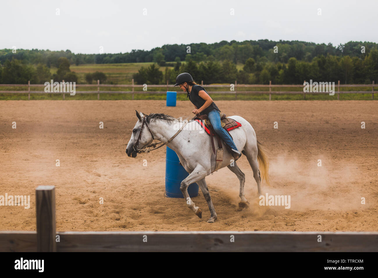 Teen girl riding horse autour de baril en arena Banque D'Images