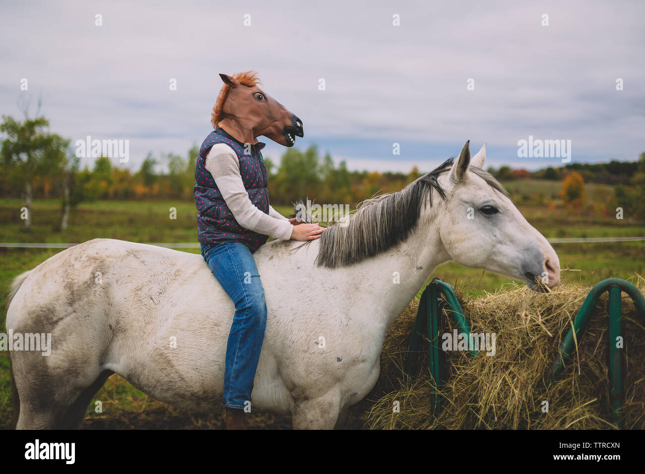 Jeune fille à cheval assis sur son cheval masque Banque D'Images