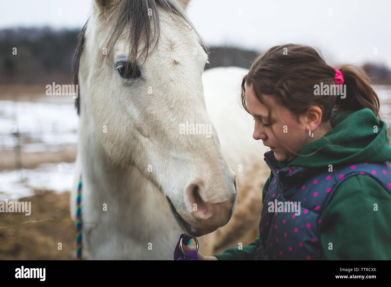 Fille de parler à son cheval blanc dans les pâturages Banque D'Images