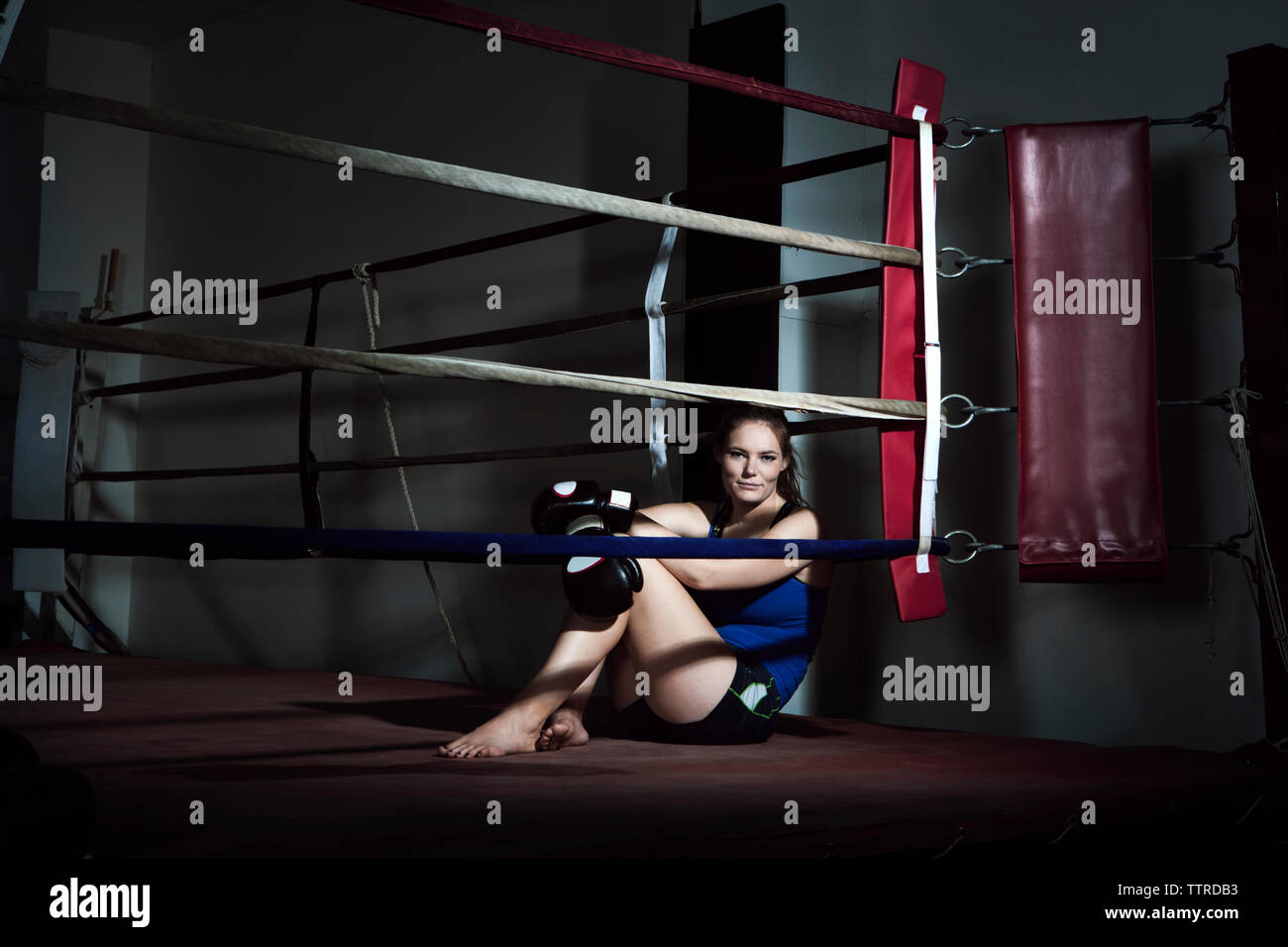 Fatigué de la sportive assis dans ring at gym Banque D'Images