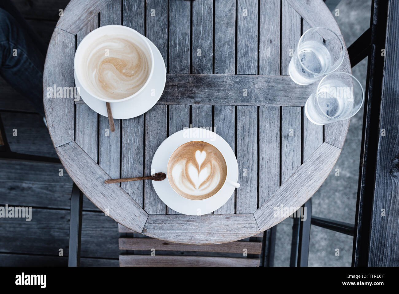 Vue de dessus de tasses à café et verres d'eau sur la table en bois Banque D'Images Vue de dessus de tasses à café et verres d'eau sur la table en bois Banque D'Images