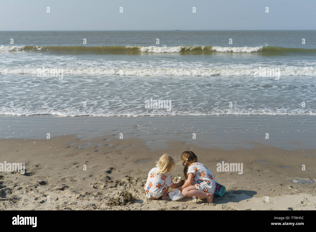 Les jeunes sœurs building Sand Castle à la plage Banque D'Images
