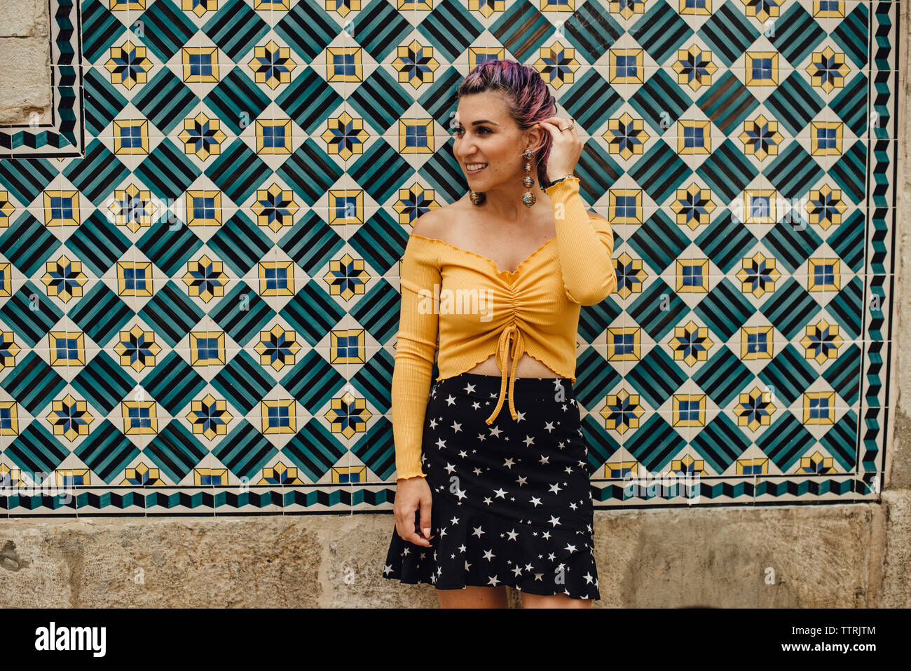 Jeune femme au mur recouvert de carreaux portugais Banque D'Images