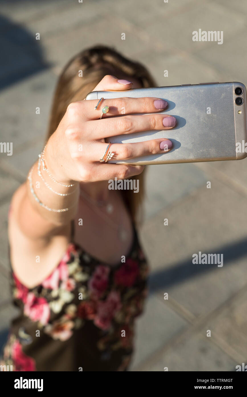 Portrait de femme portant des bijoux en se tenant sur le sentier selfies lors de journée ensoleillée Banque D'Images
