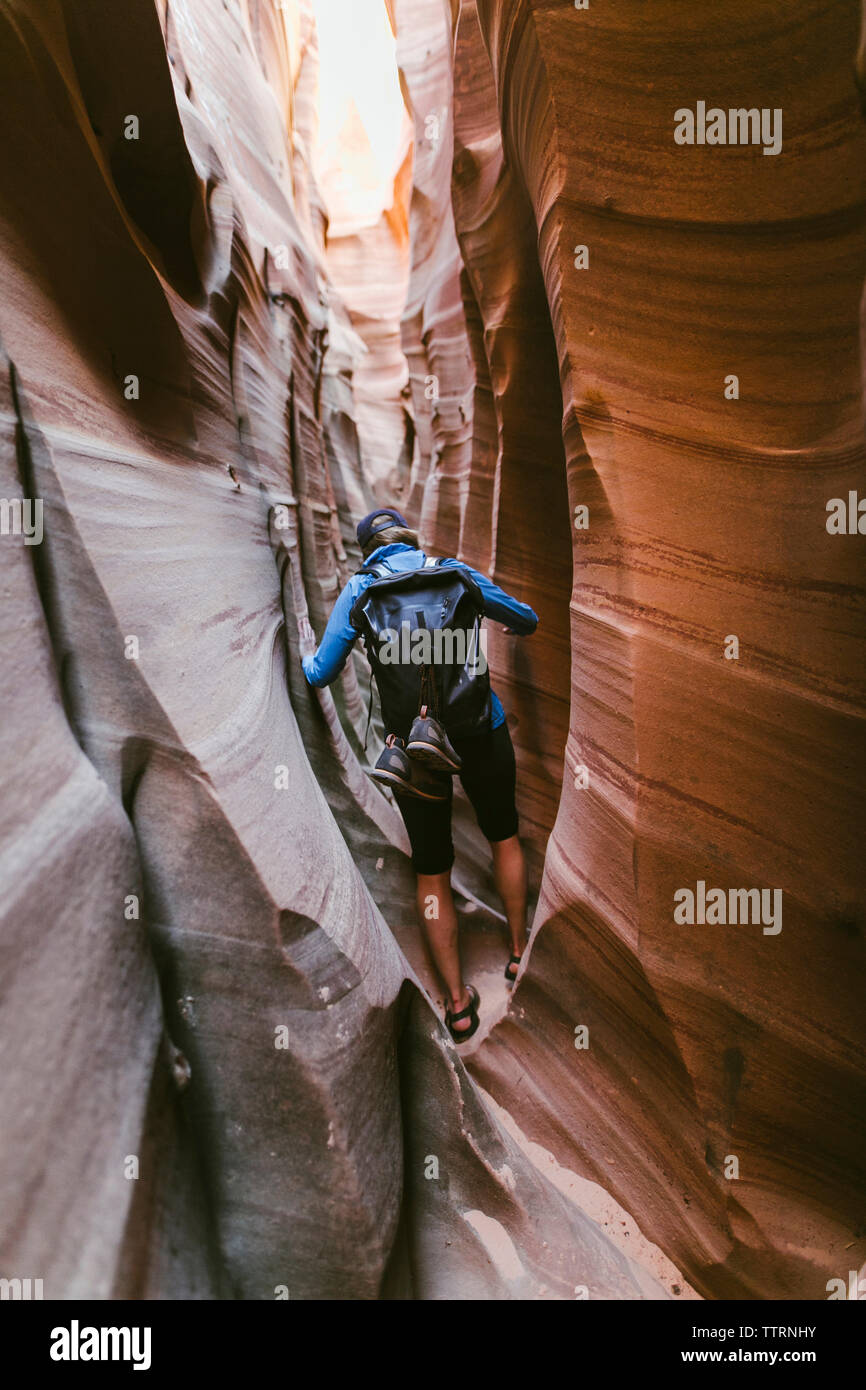 Vue arrière du female hiker avec balades à dos au milieu d'étroits canyons Banque D'Images