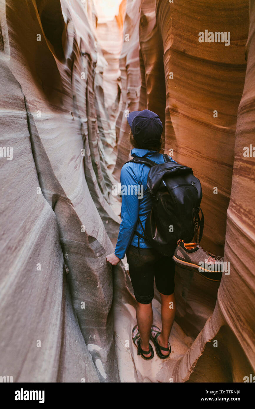 Vue arrière du female hiker with backpack article au milieu d'étroits canyons Banque D'Images