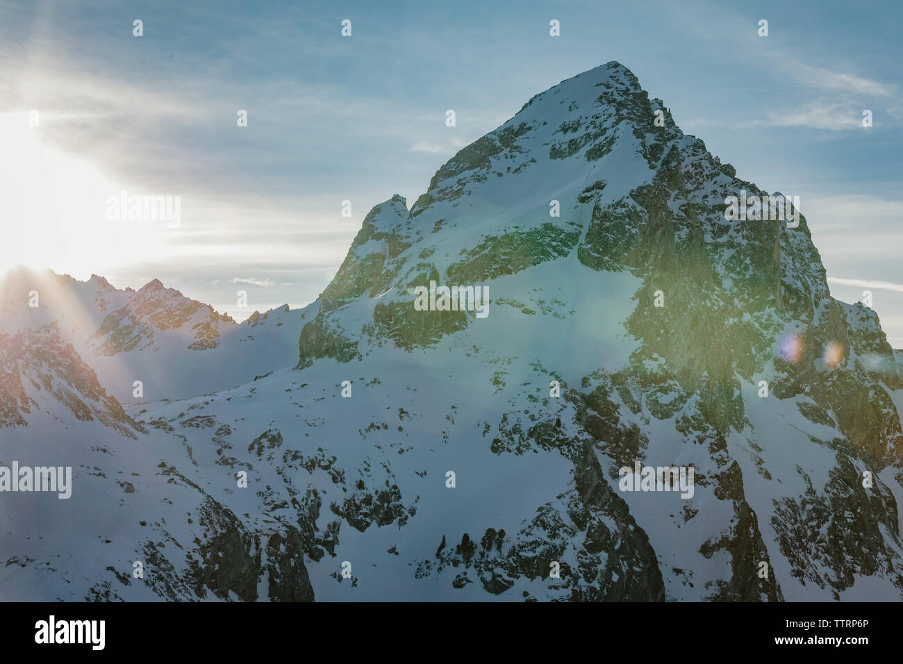 Avis de buck montagne en hiver juste avant le coucher du soleil avec sun flare Banque D'Images
