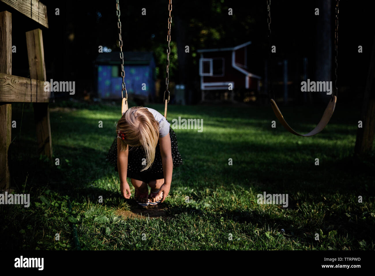 Fille se balançant à l'aire de jeux Banque D'Images