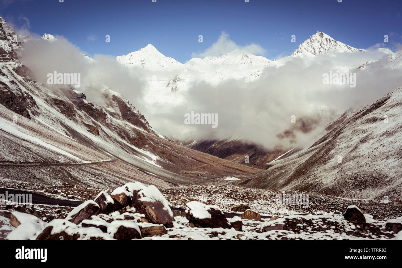 Vue panoramique des montagnes aux sommets enneigés against sky Banque D'Images