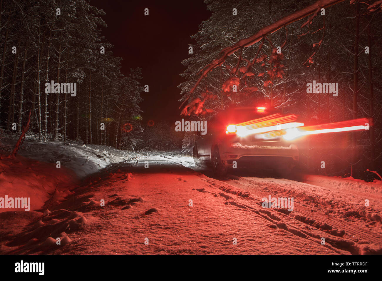 Allumé en voiture sur le terrain couvert de neige dans la nuit Banque D'Images