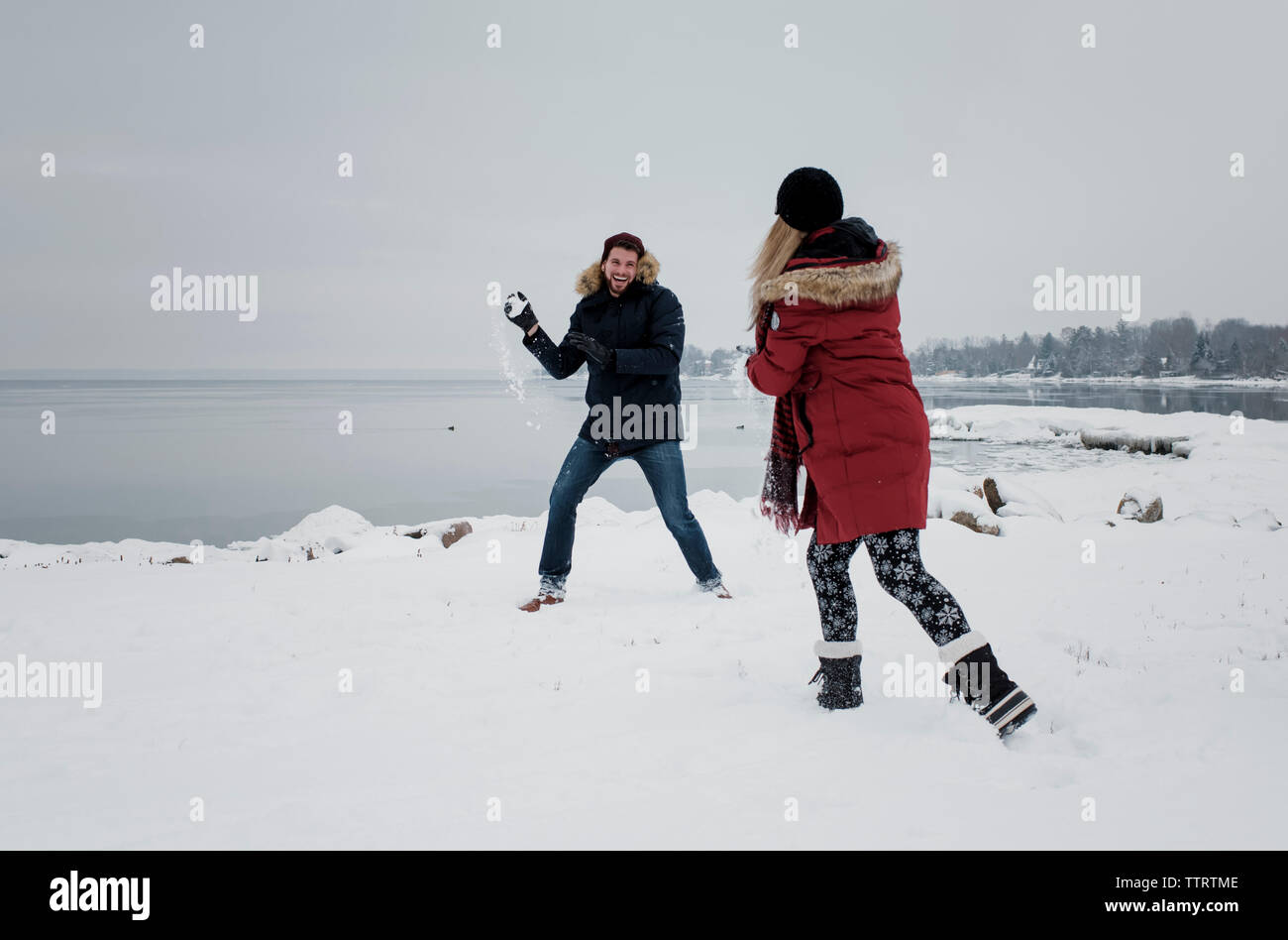 Amis jouant avec de la neige à la sky en hiver Banque D'Images