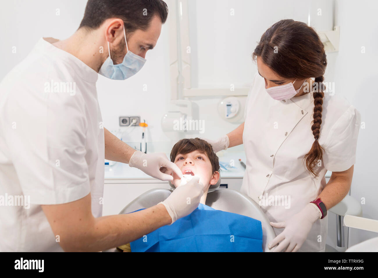 L'examen de dentiste dents du patient par l'assistant en clinique médicale Banque D'Images