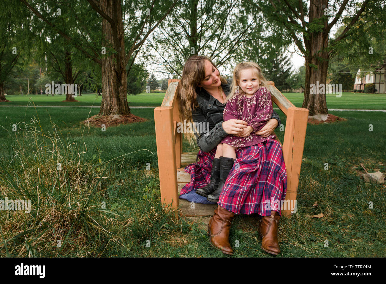 Portrait de fille assise sur les genoux de mère at park Banque D'Images