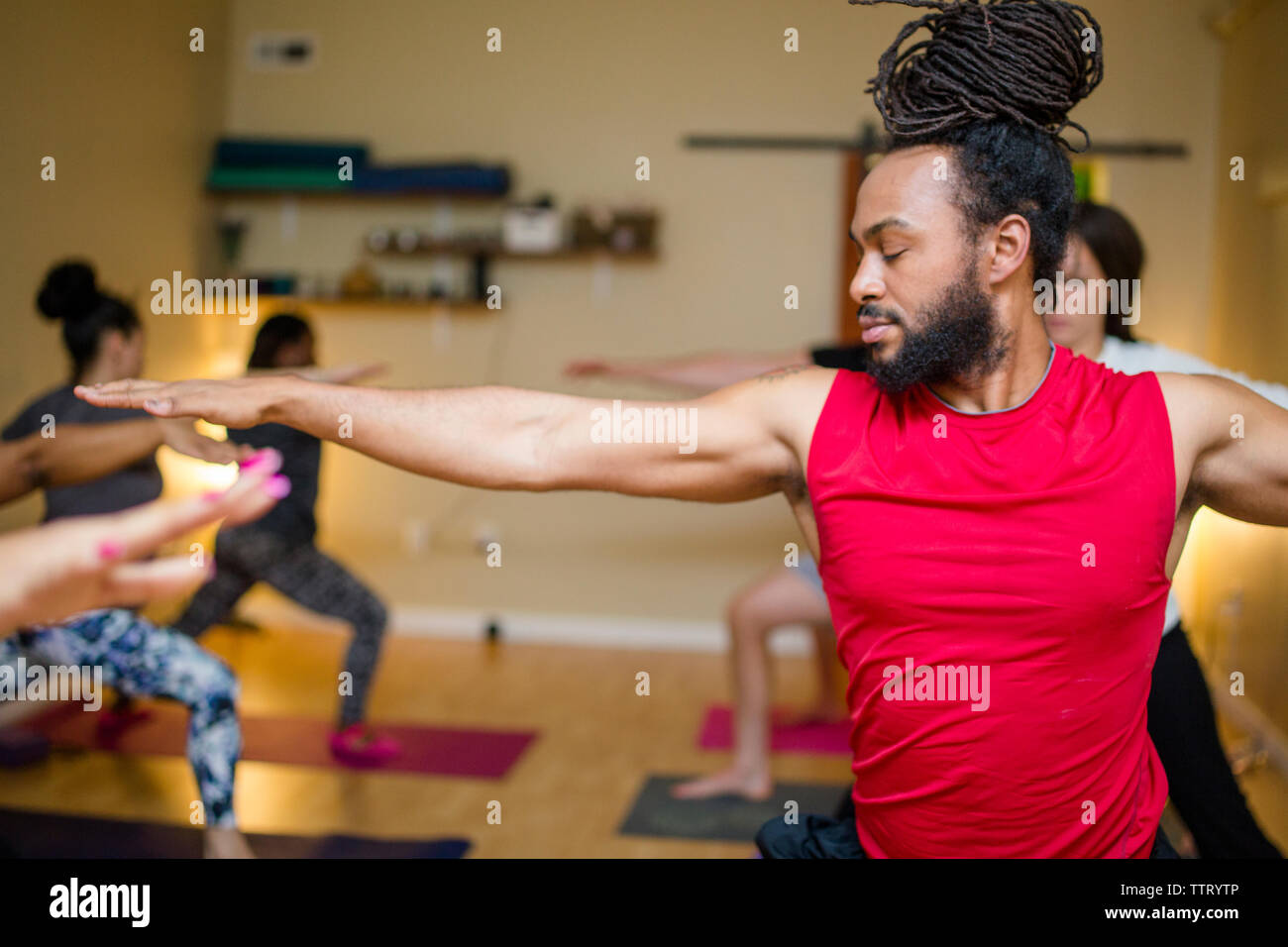 Un bel homme pratique le yoga dans une classe de yoga Banque D'Images