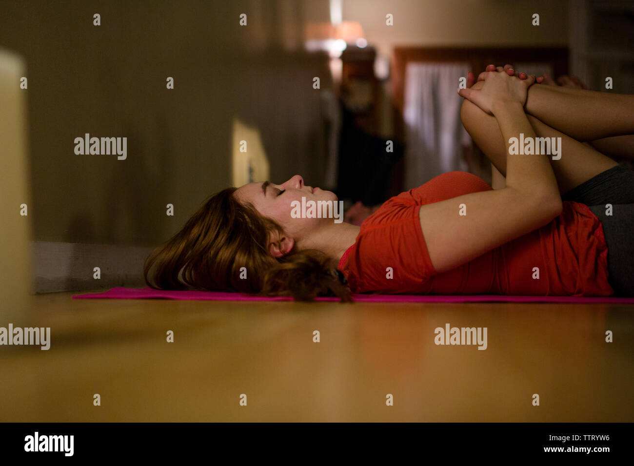 Une jeune femme se détend sur son dos dans une classe de yoga Banque D'Images