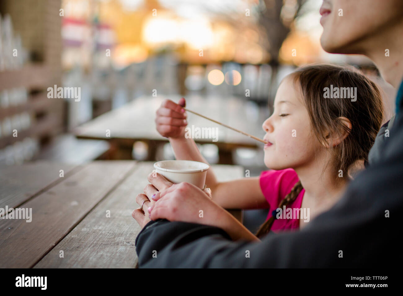 Un enfant heureux gorgées sur une paille et des boissons cacao avec son père au café Banque D'Images